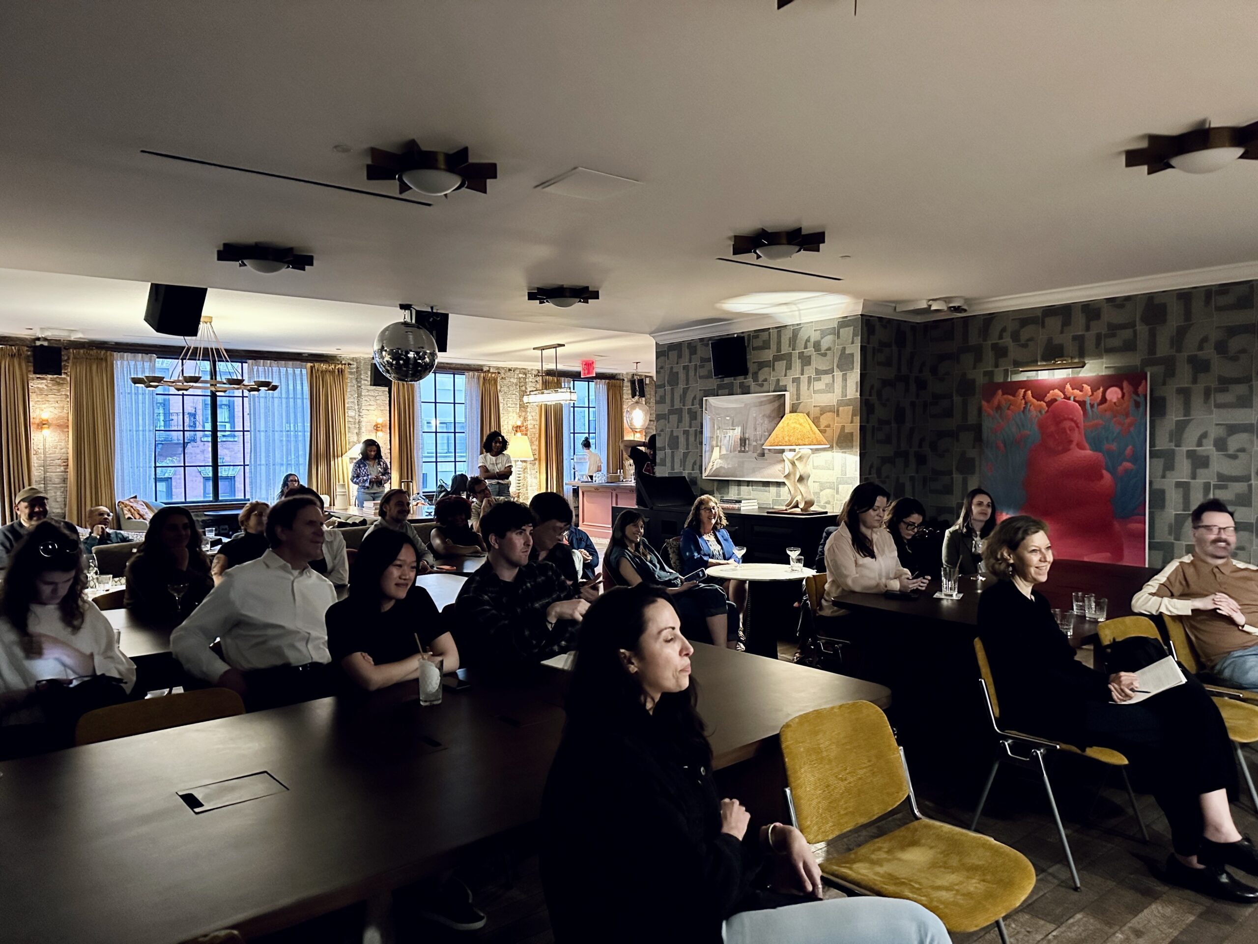 Image description: Room of 30 people sit in Ludlow House in New York City, attending the Elevate Your Impact event.